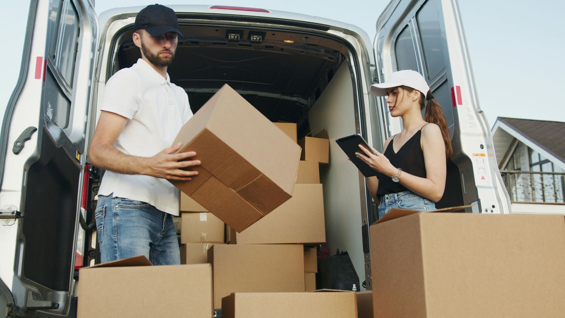 A man and a woman are loading boxes into a van.