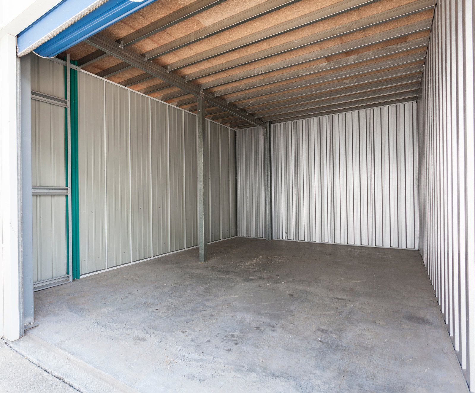 An empty garage with a wooden ceiling and concrete floor