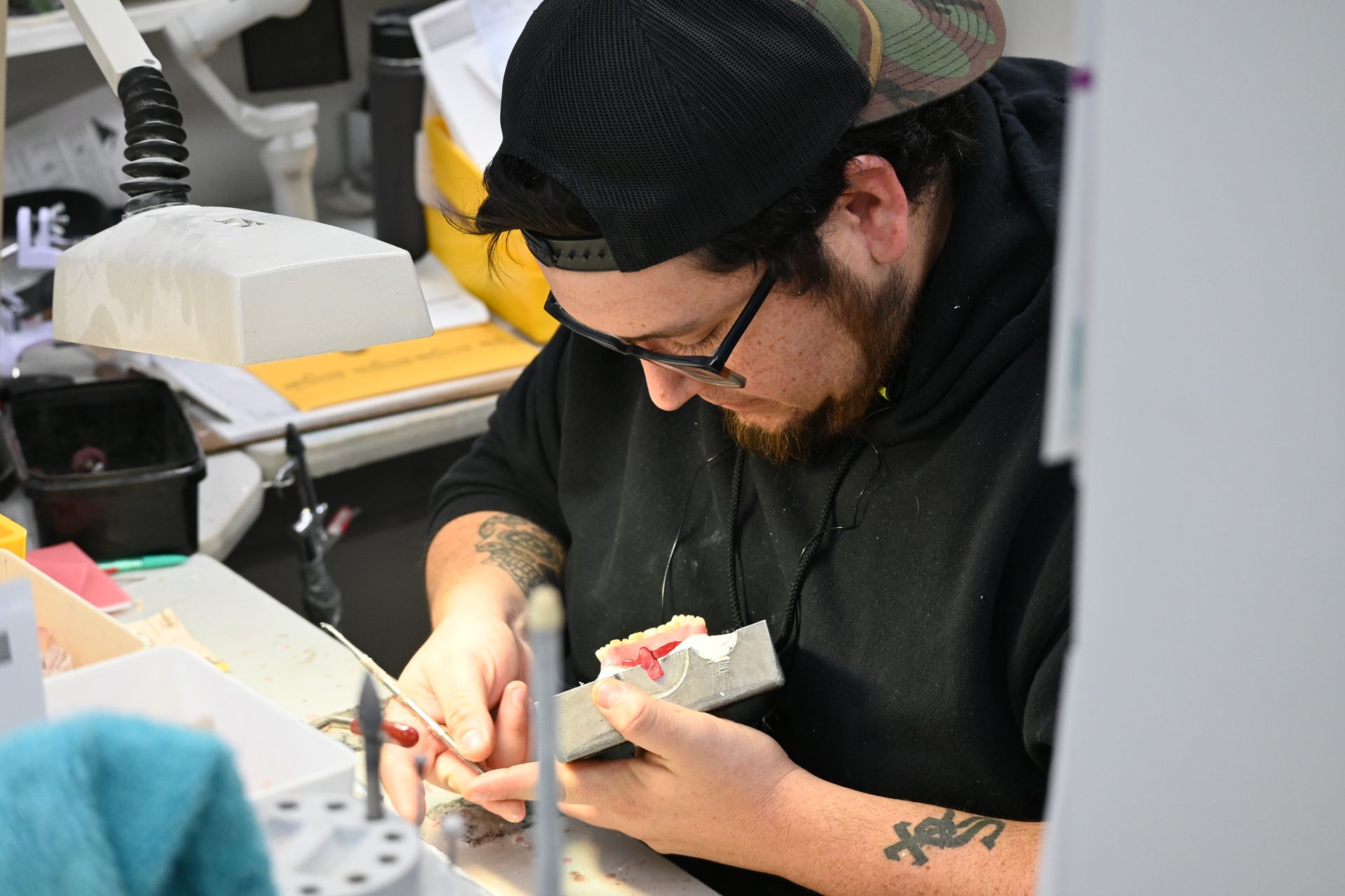 tech working on dentures in dental lab in stl