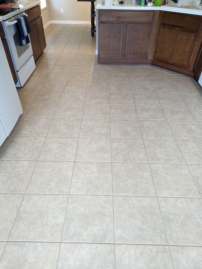 A kitchen with tile floors and wooden cabinets