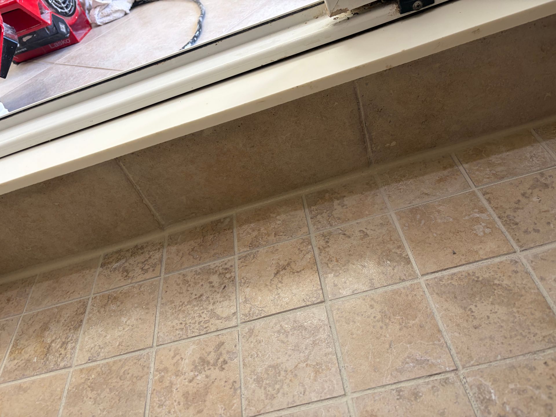 White tiled shower wall with gray grout.