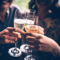 Un groupe de personnes trinque avec des coupes de champagne.