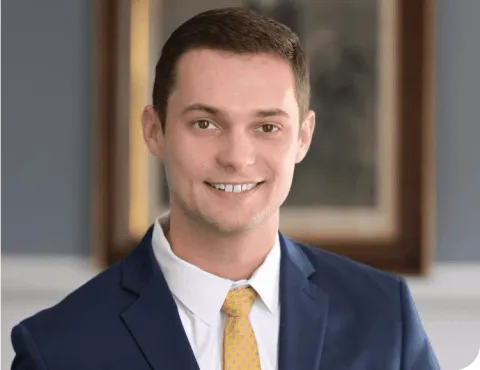 A man in a suit and tie is smiling for the camera.