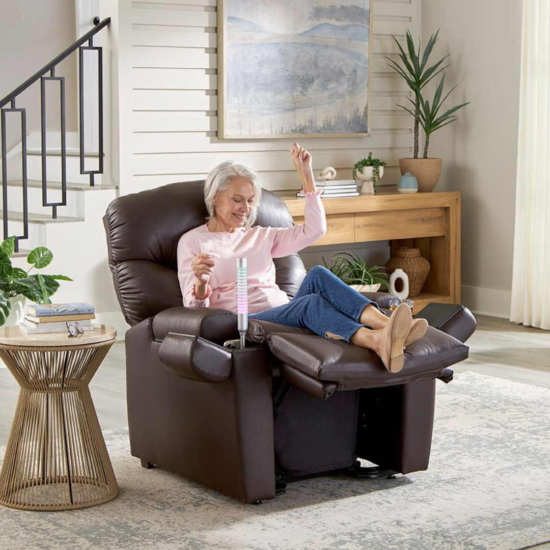 Woman in recliner with drink, arm raised. Home setting. Brown leather chair, rug, neutral decor.
