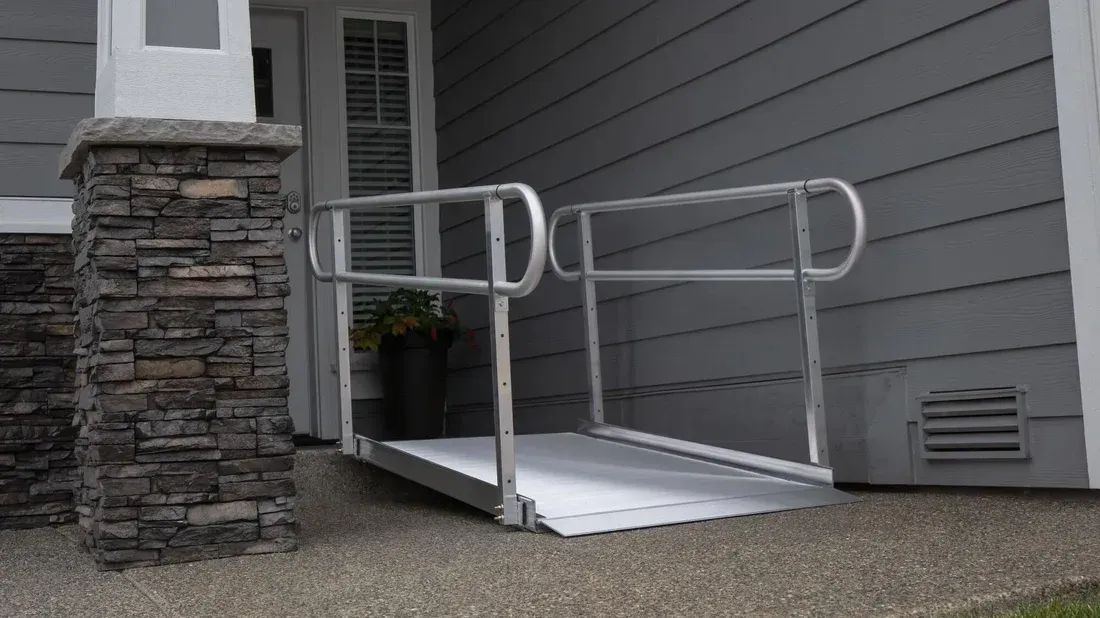 Aluminum ramp with handrails provides accessible entrance to a home's front door.