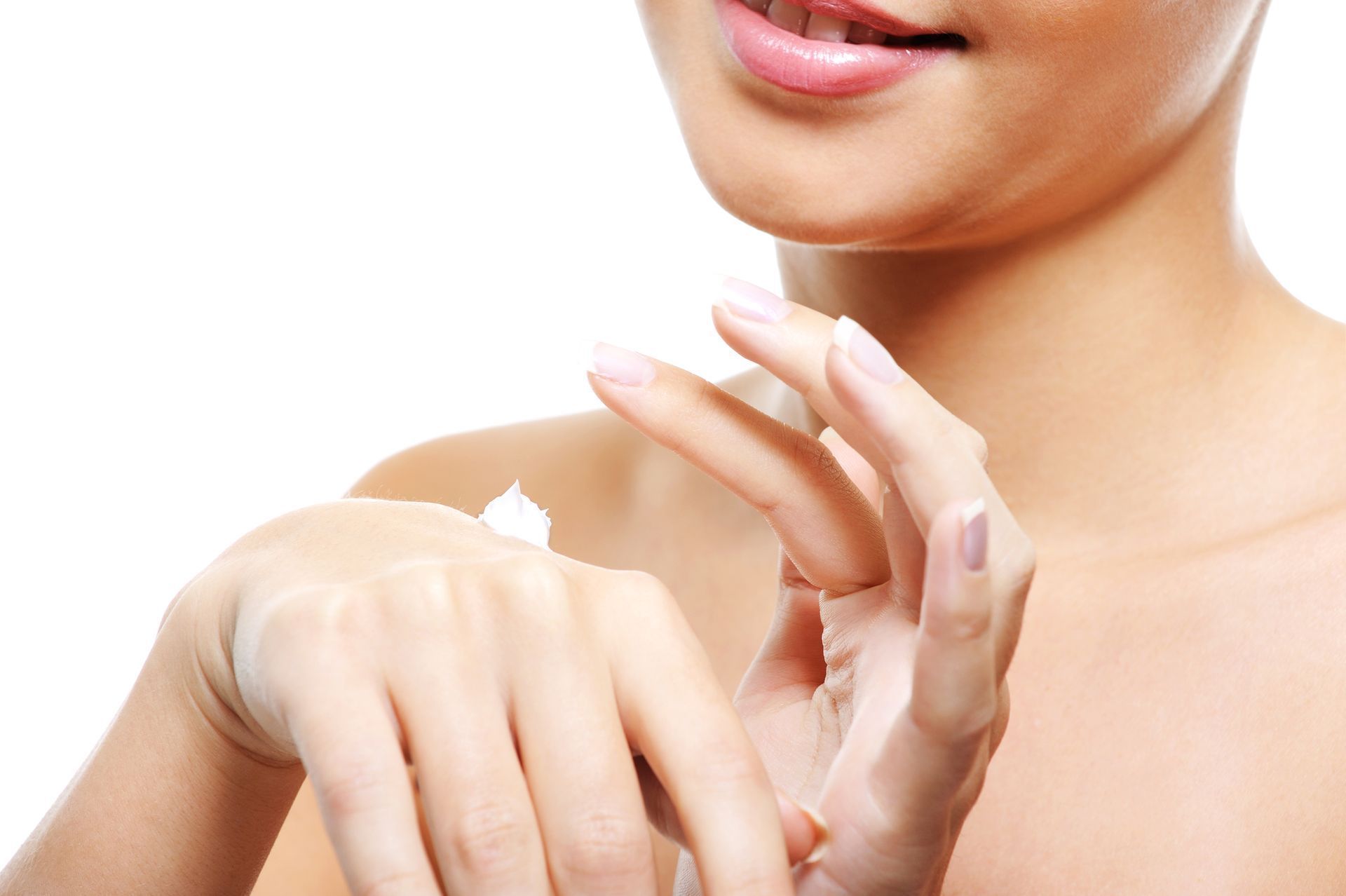 Woman applying cream to her hand, soft skin, white background.