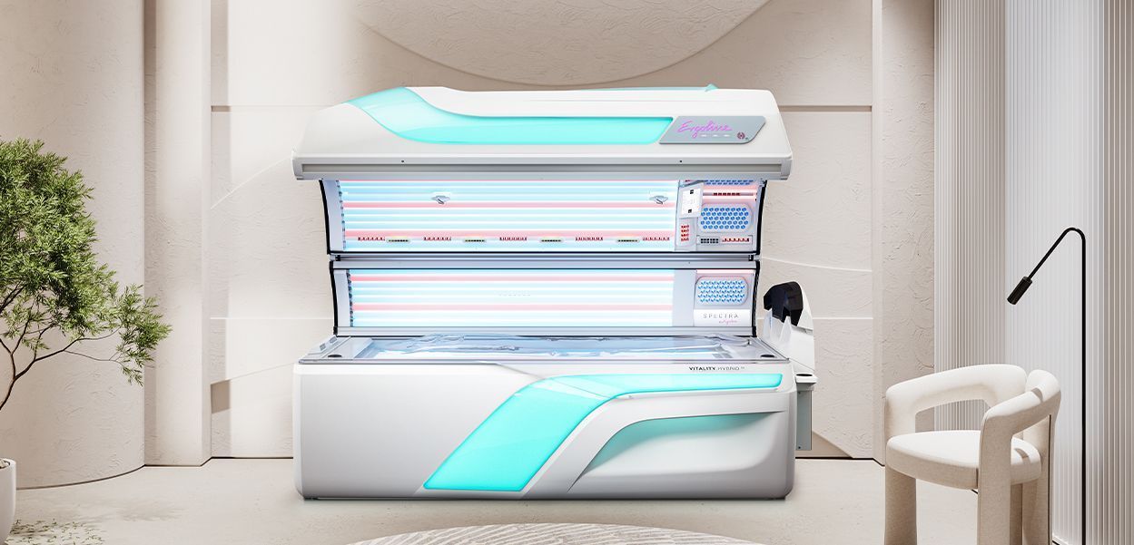 A tanning bed in a bright, modern room, with turquoise accents, a chair, and a floor lamp.