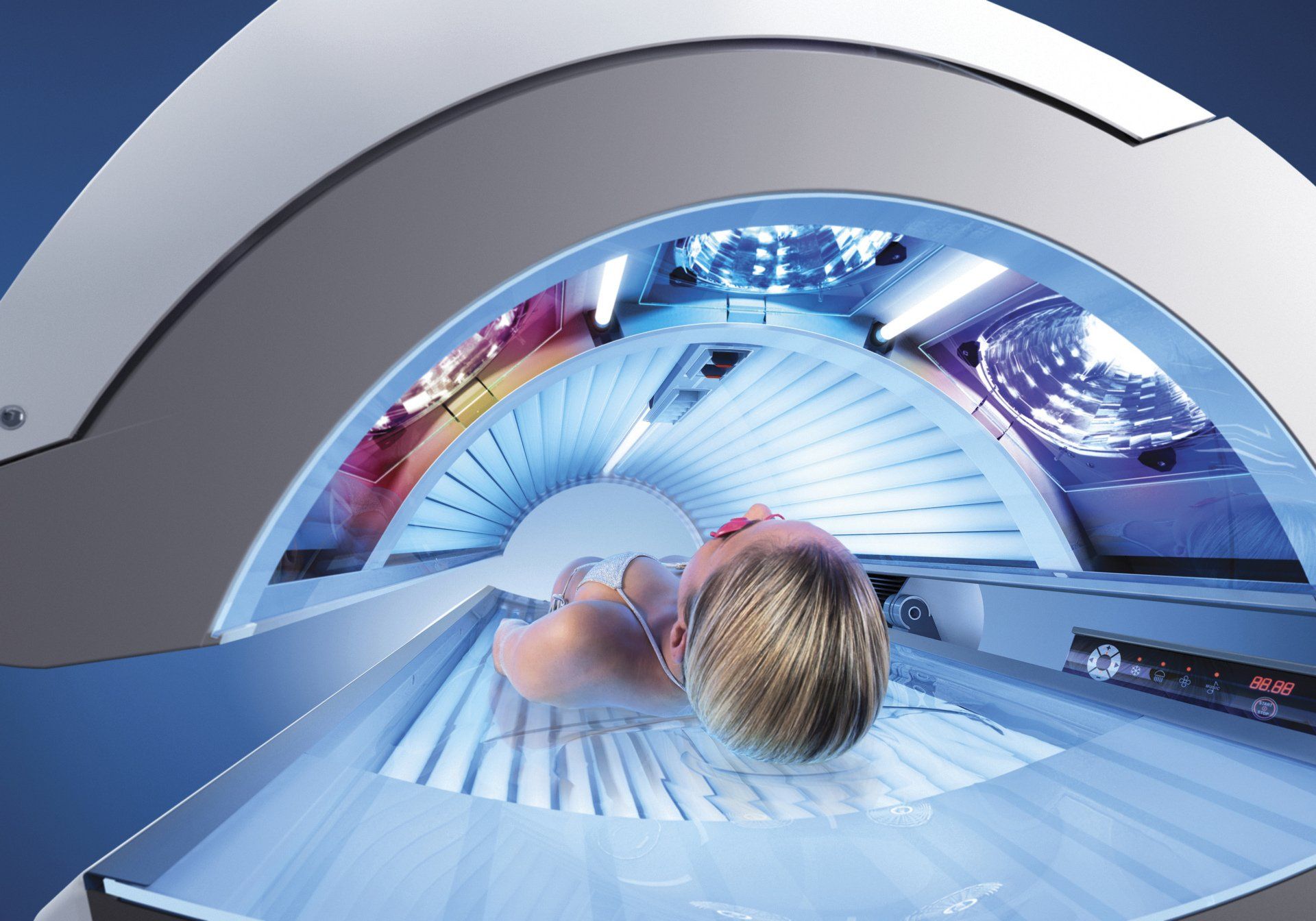 Person laying in a tanning bed, exposed to blue UV light.
