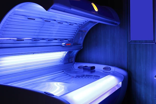Tanning bed with blue lights, in a dimly lit room.