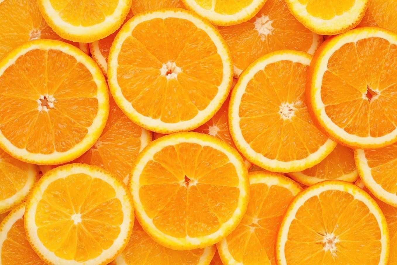 Orange slices, bright orange, close-up, textured, arranged in a pile.