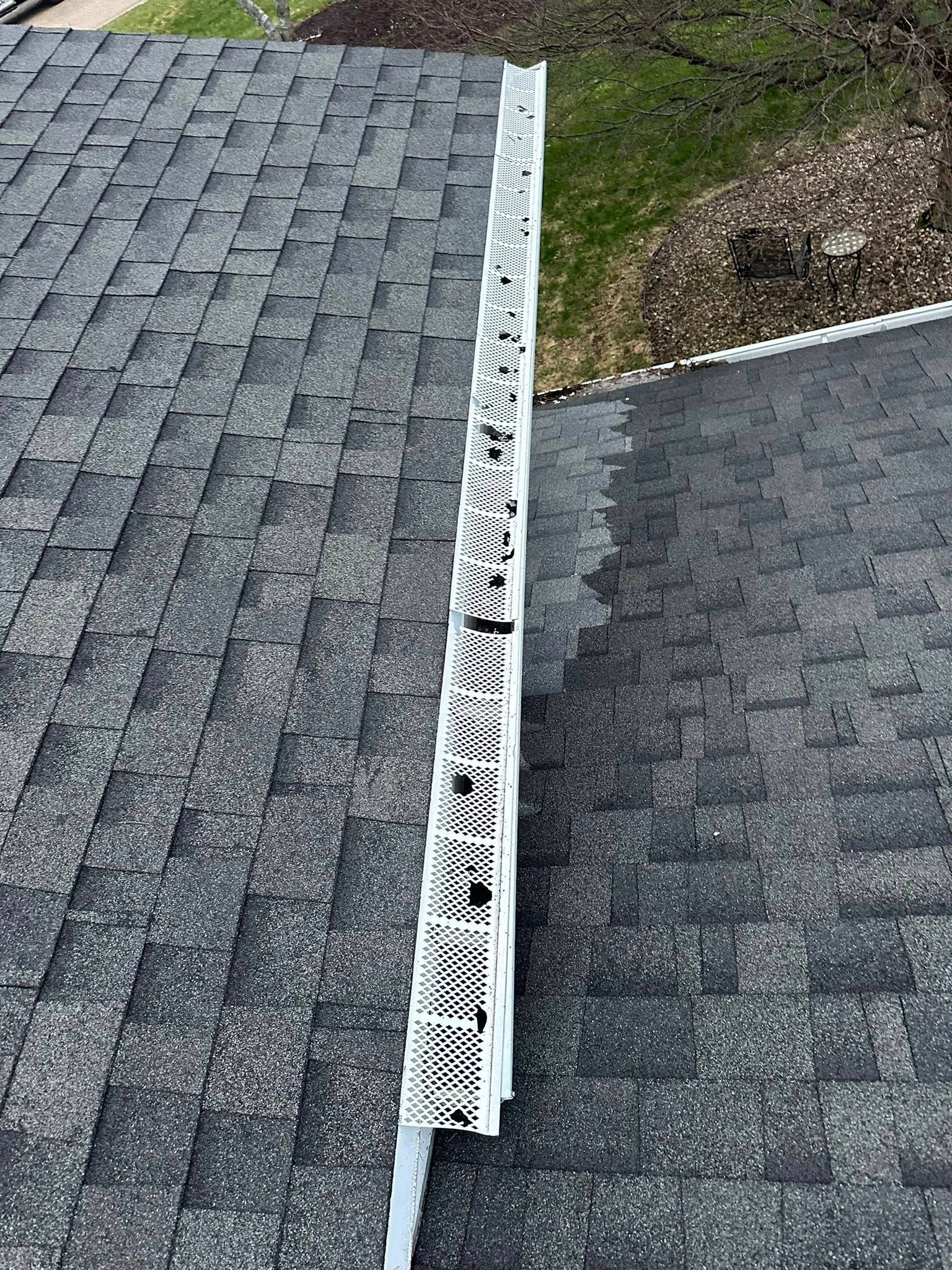 White plastic ridge vent installed along the peak of a dark shingled residential roof.