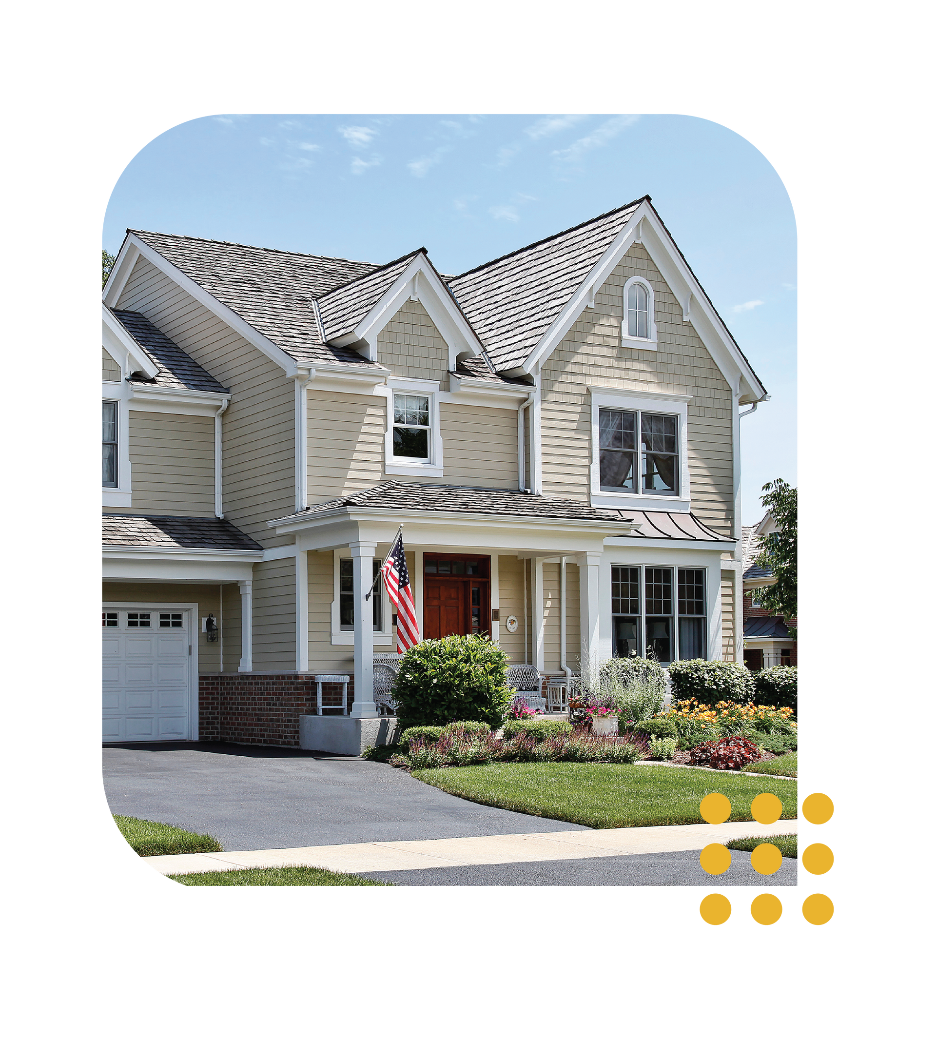 Suburban house with beige siding, white trim, and a flowered front yard under a clear sky