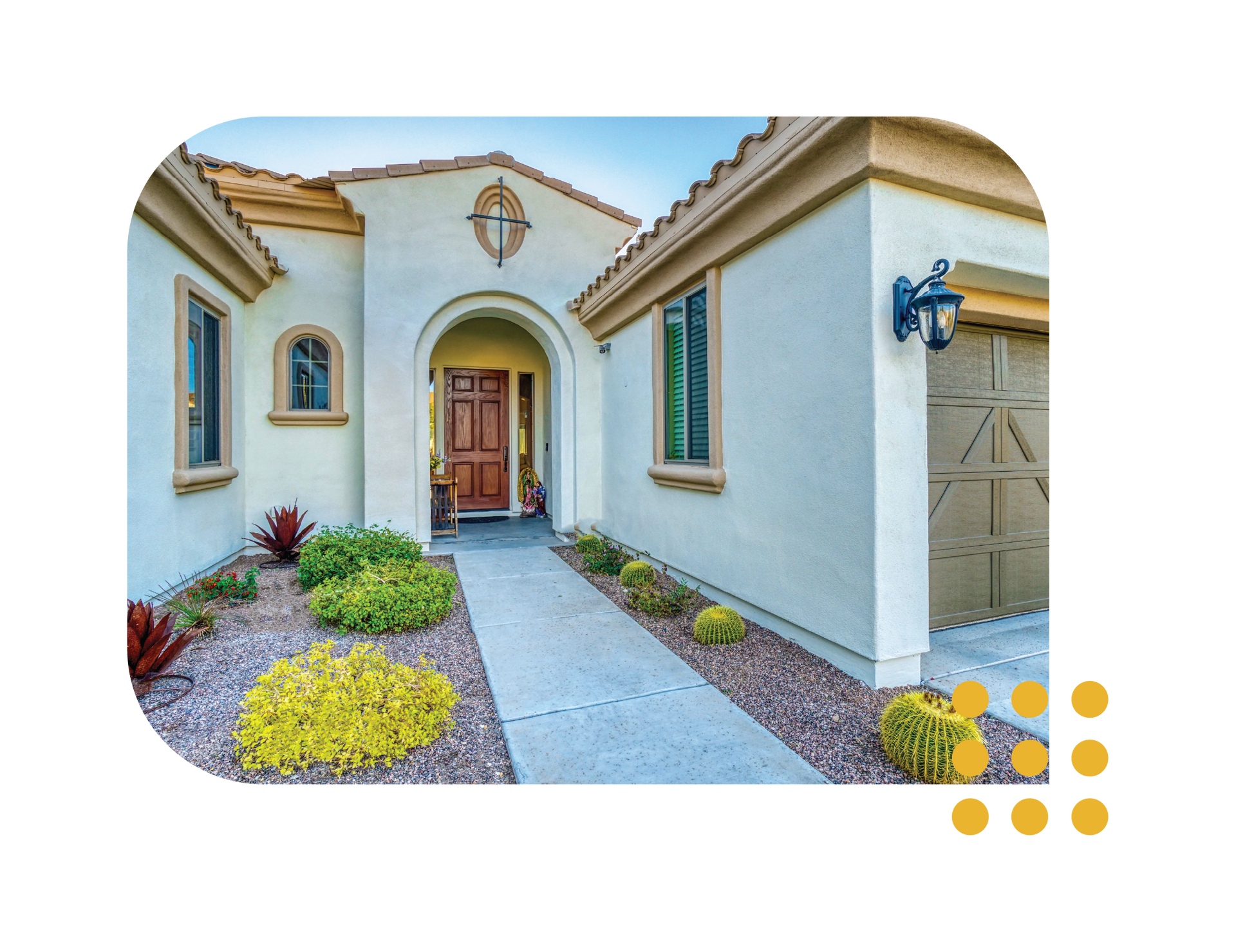 Front entrance of a stucco house with an arched doorway, gravel path, and desert landscaping