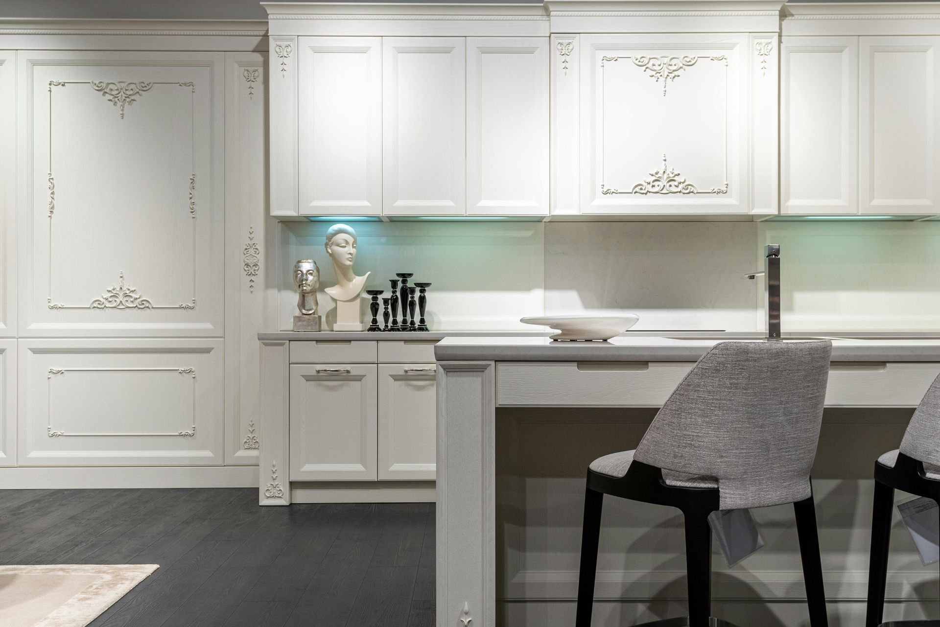 White kitchen with ornate detailing and bar seating.
