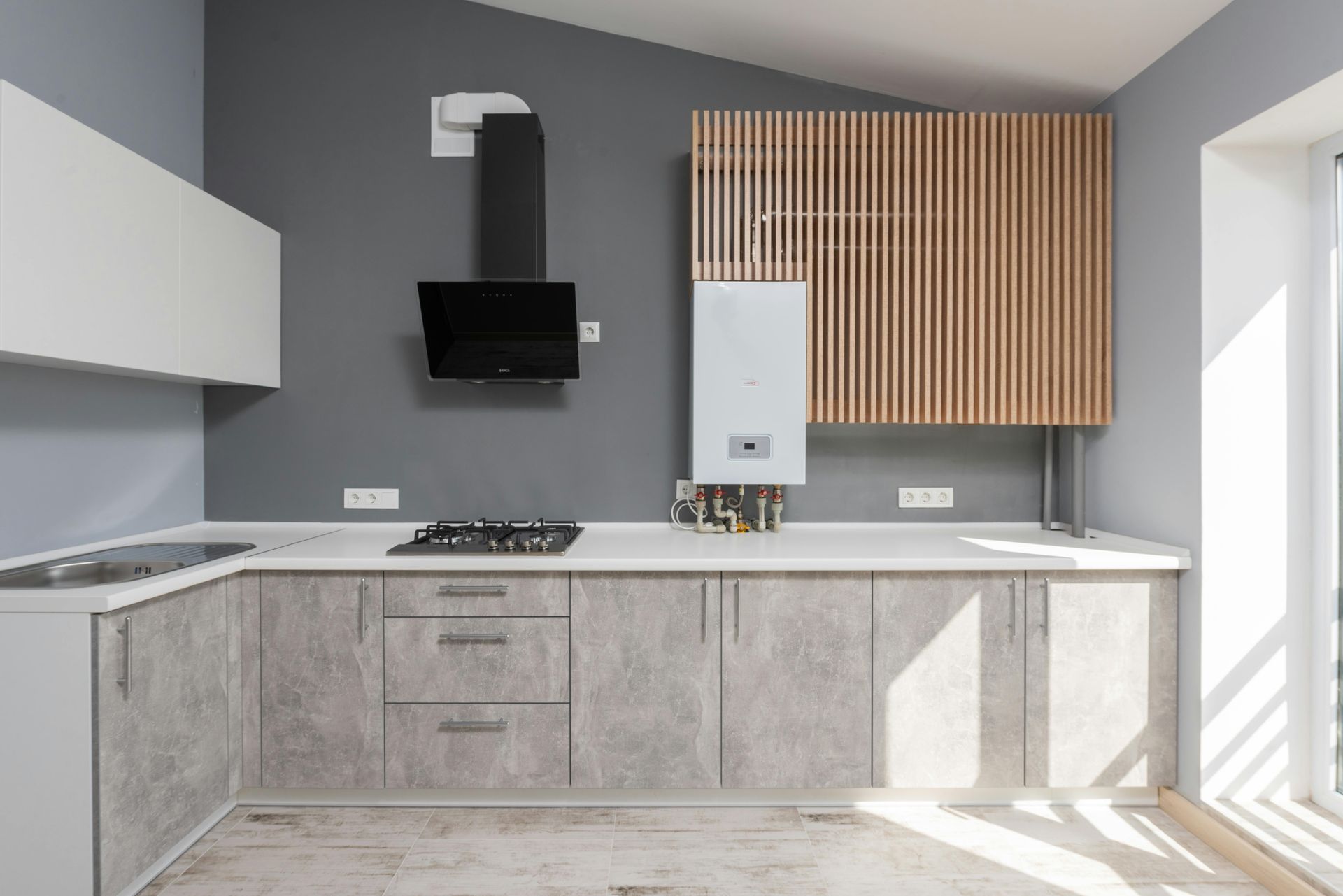 Modern kitchen with grey cabinets, white countertops, and wood accent cabinet.