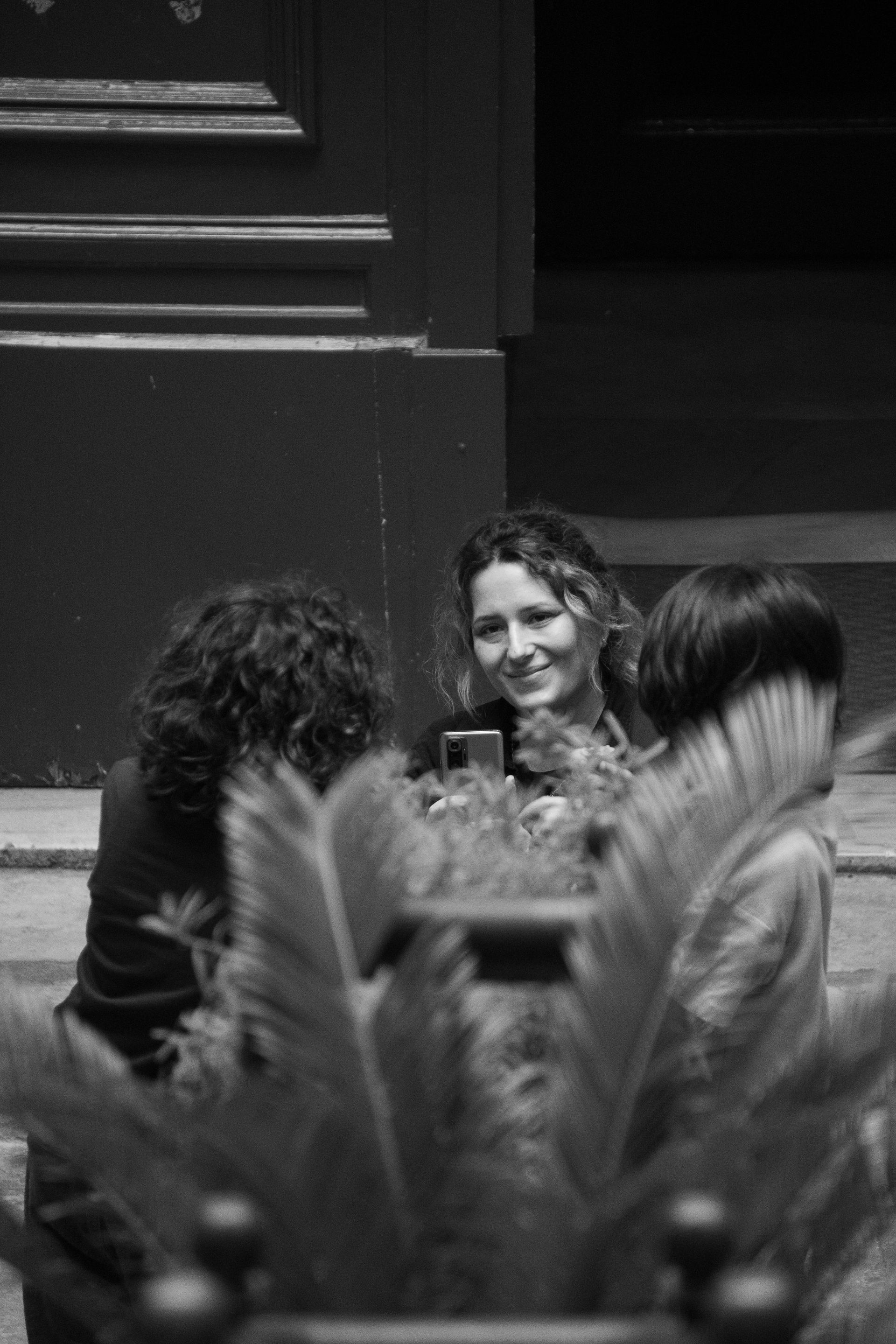 A group of women are drinking tea and chatting at a table indoors .