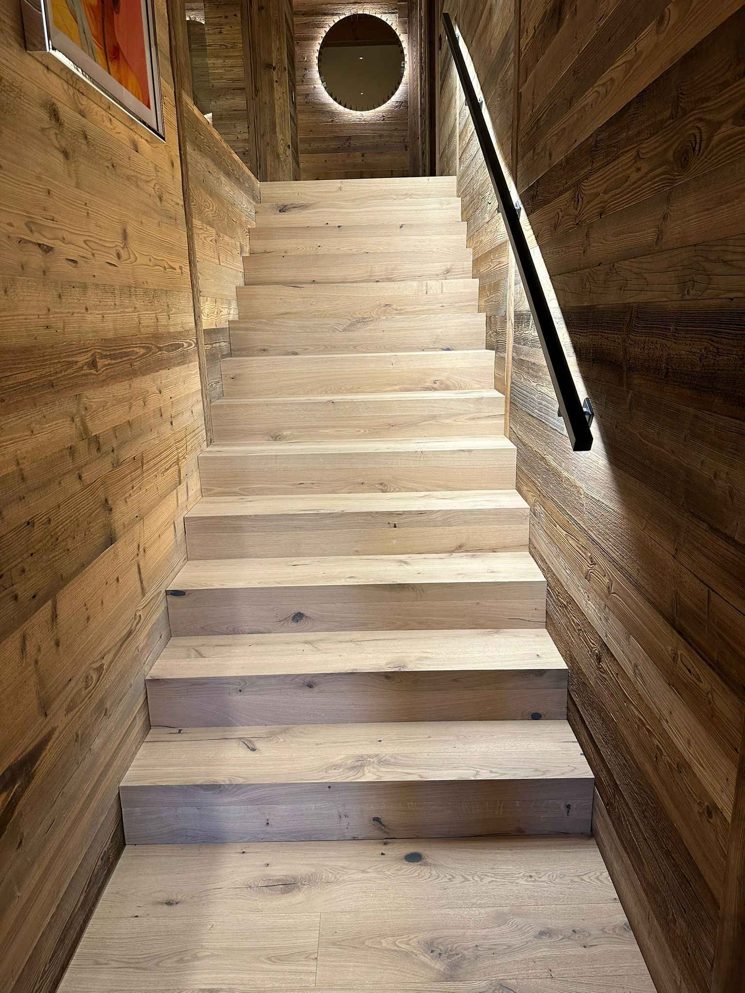 Un ensemble d'escaliers en bois menant à un mur en bois.