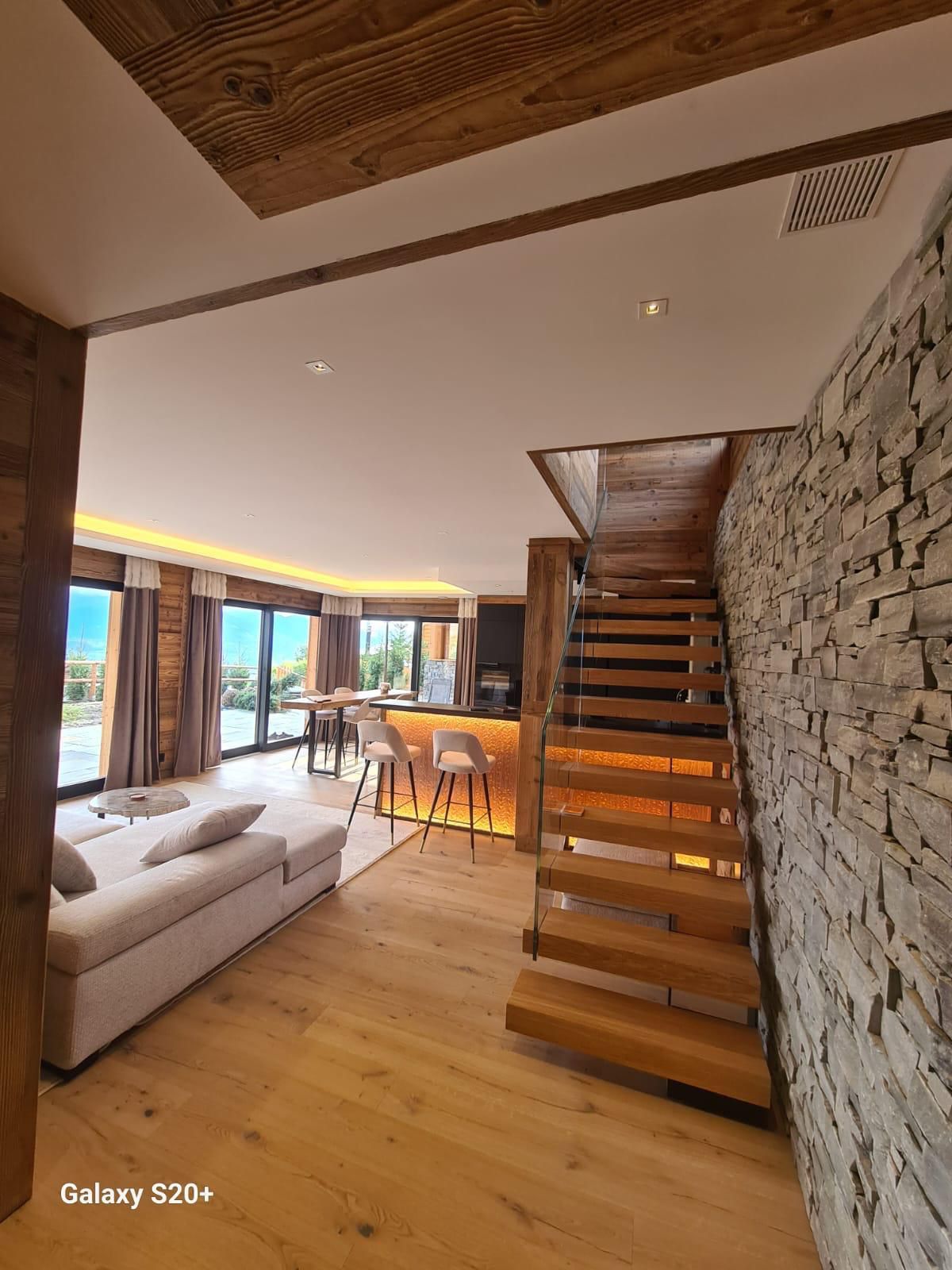 Un salon avec un escalier en bois menant au deuxième étage.