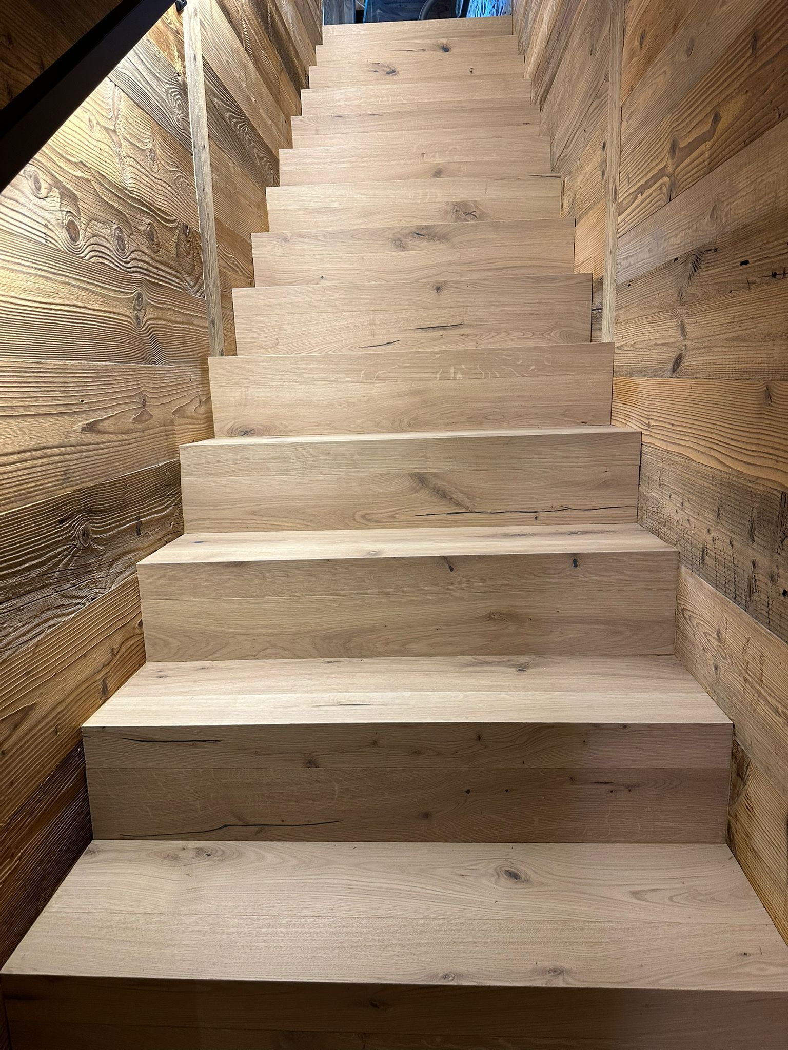 Un ensemble d'escaliers en bois menant à un mur en bois.