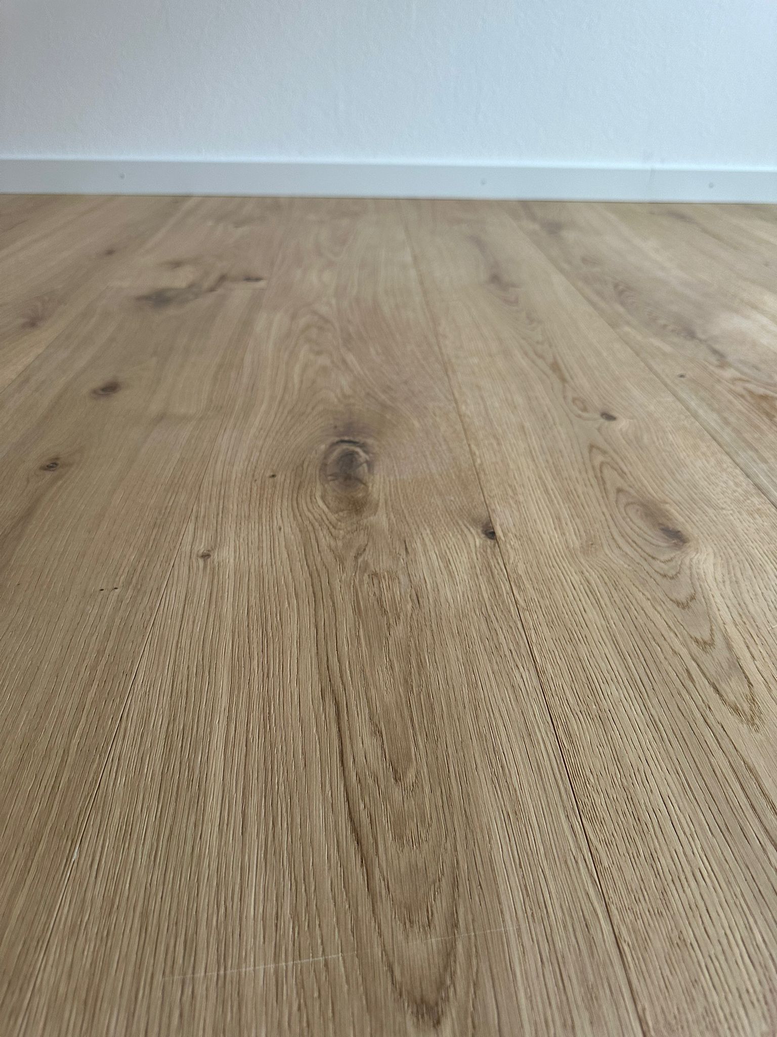 Un gros plan d'un plancher en bois dans une pièce vide.