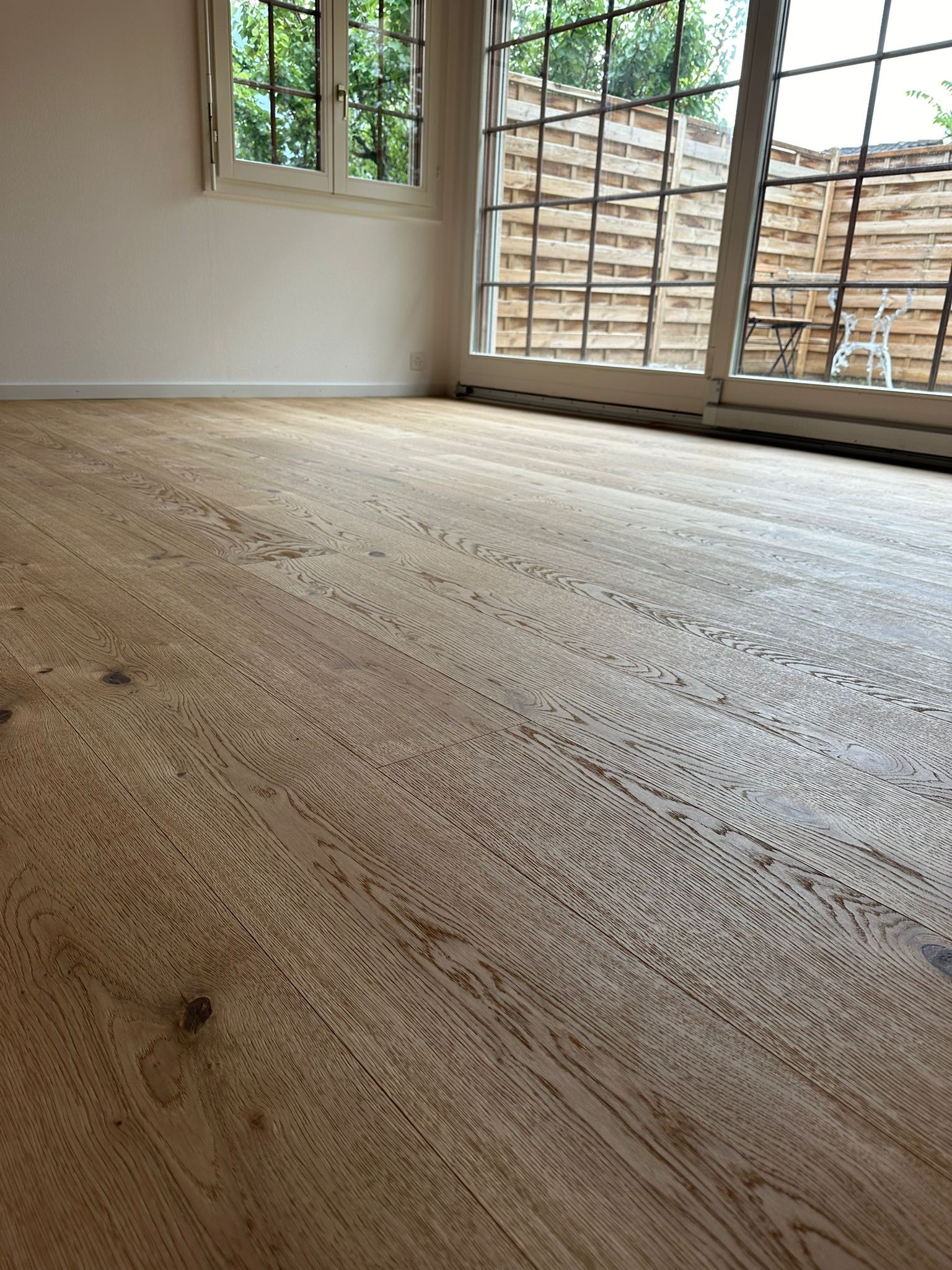 Une pièce vide avec un plancher en bois et une fenêtre