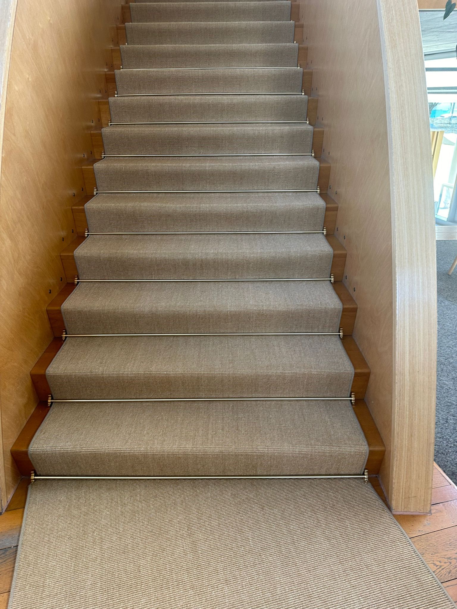 Un escalier avec un tapis sur les marches.