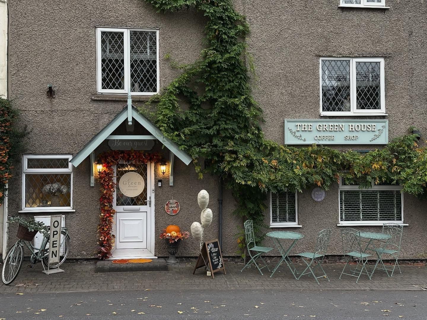 The White House tea room exterior with ivy, windows, a door, and outdoor seating.