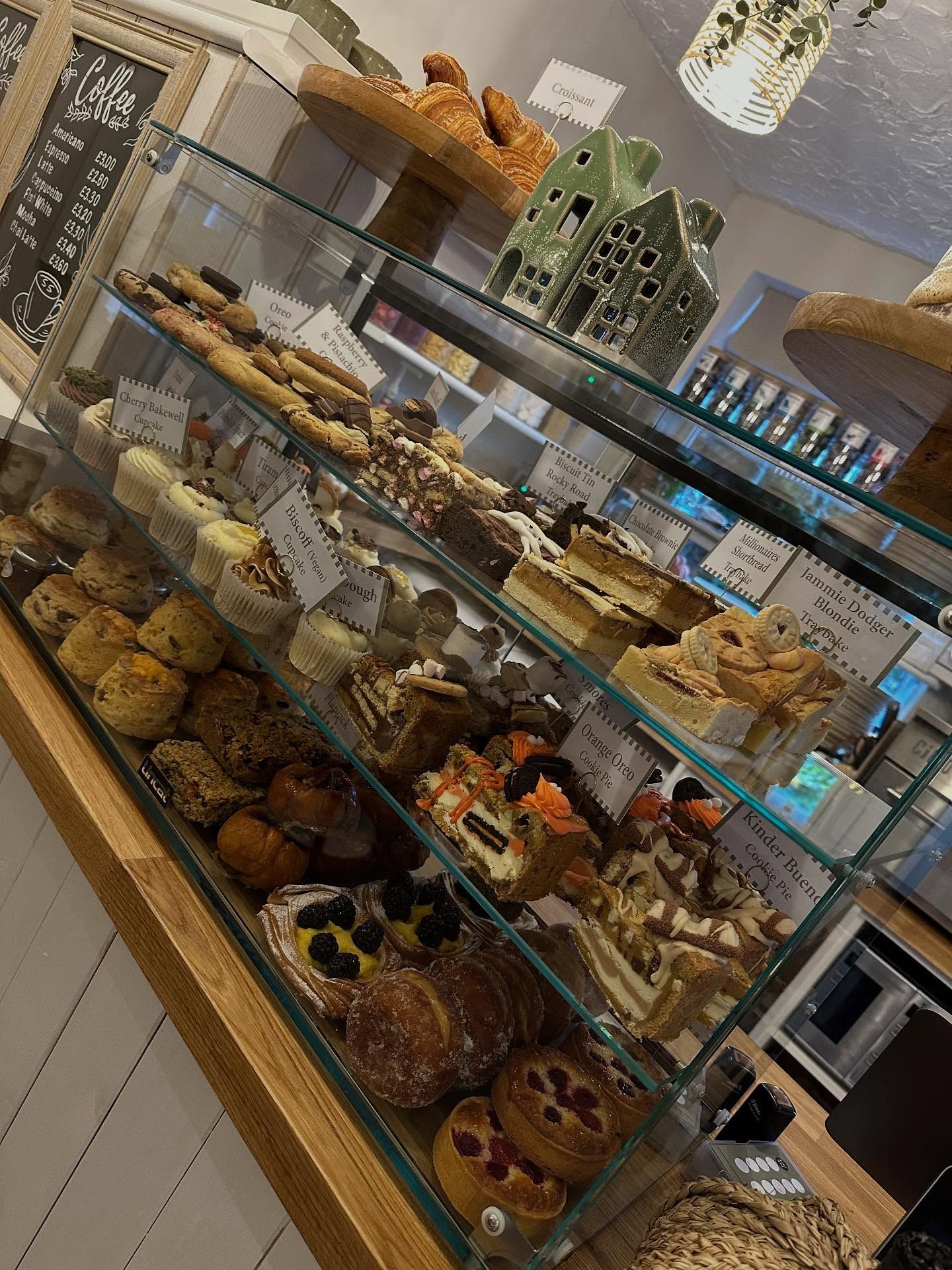 A glass display case filled with various pastries and cakes in a bakery.