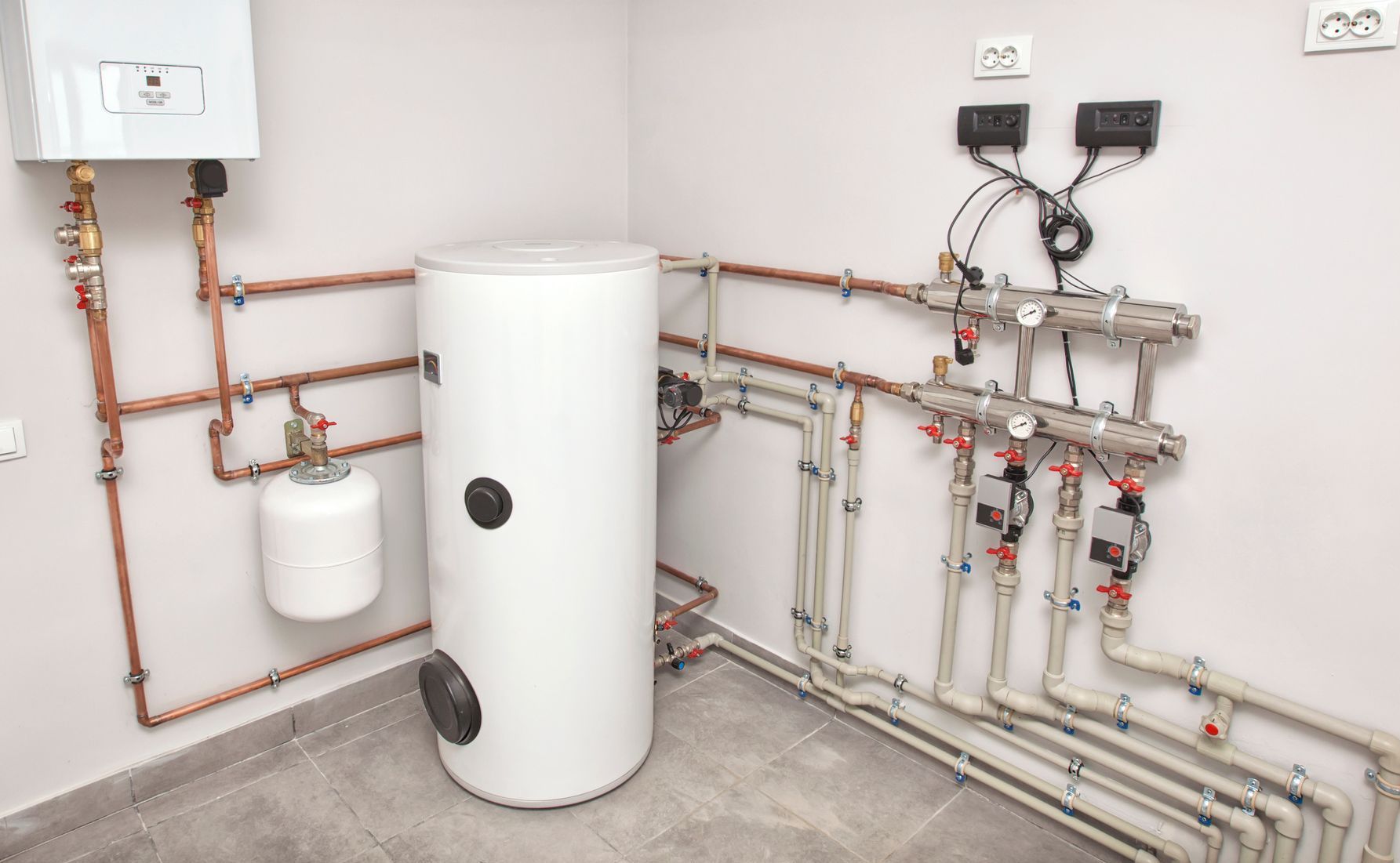 A room with a water heater and a lot of pipes.