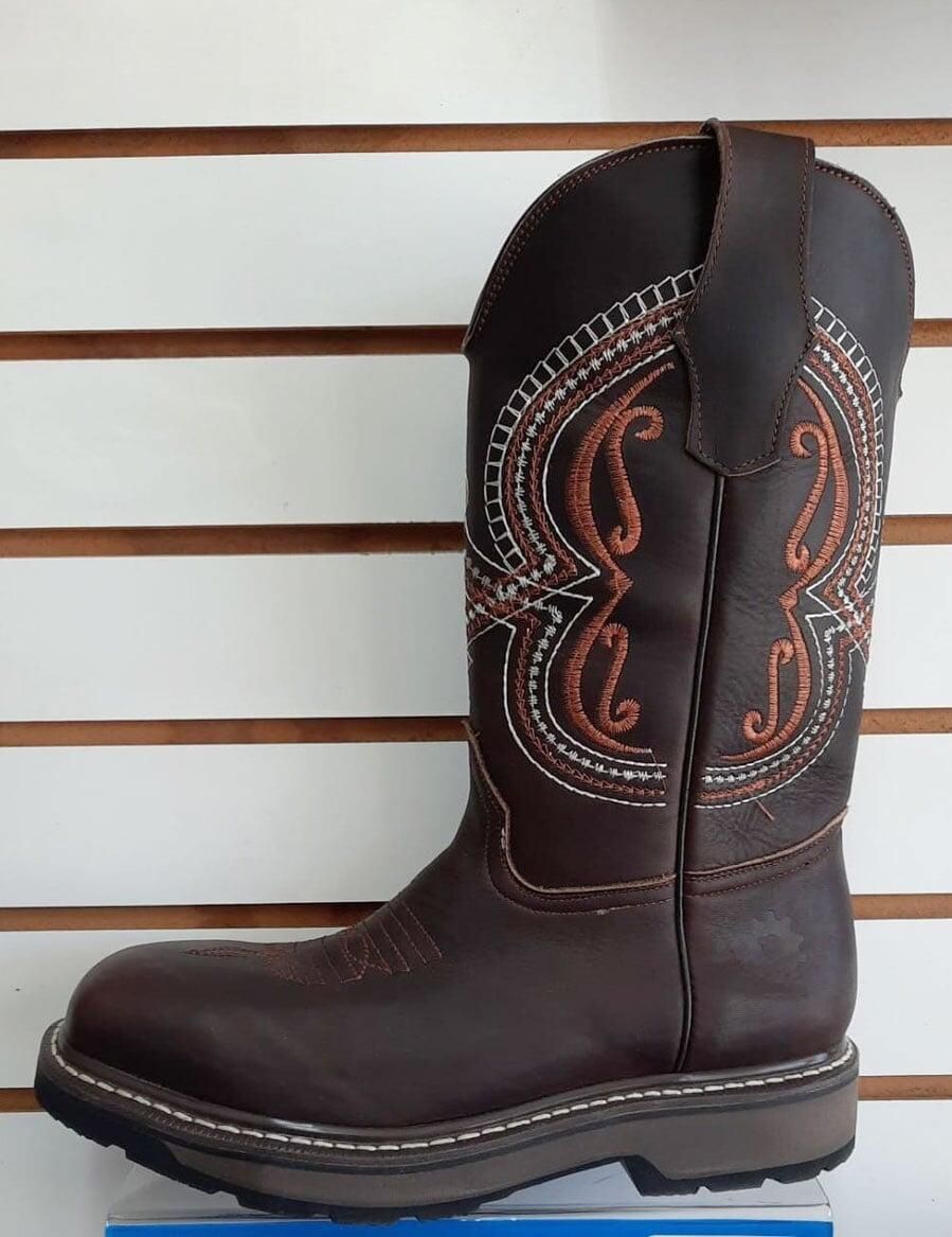 Un par de botas de vaquero marrones están sobre un estante.