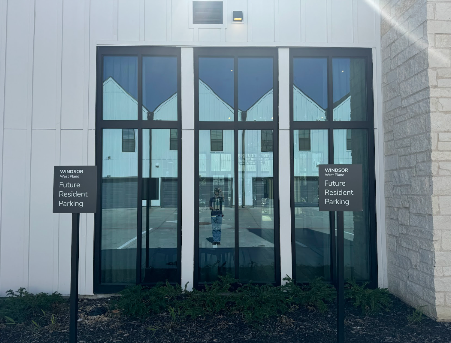 Glass double doors with small signs, set in a white building entrance