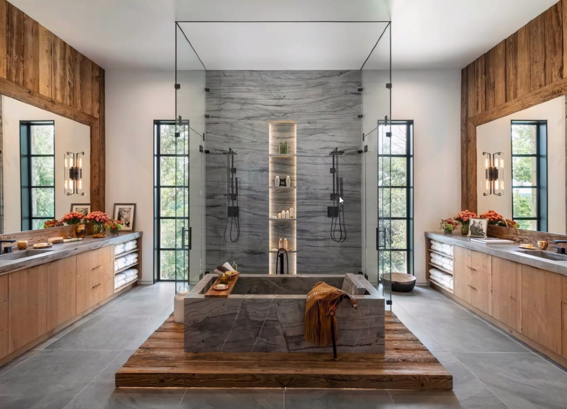 Modern bathroom with dual vanities, freestanding tub, and central shower under skylight