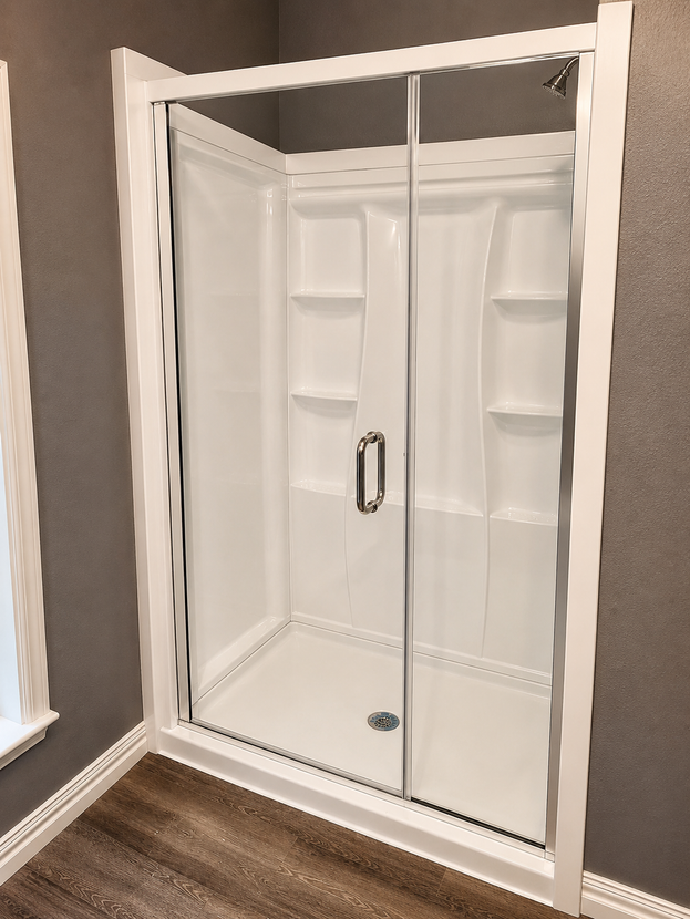 White shower enclosure with sliding glass doors in a bathroom corner.