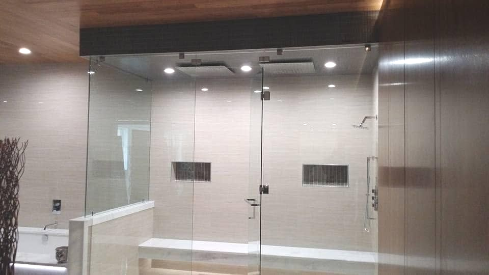 Modern glass double doors in a sleek interior lobby with metal walls and ceiling lights