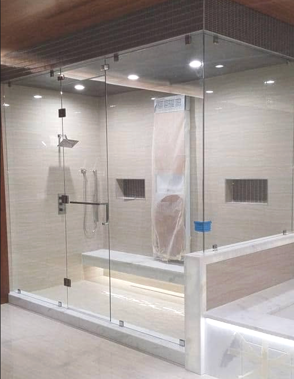 Glass shower enclosure with tiled walls, wooden ceiling, and white bathtub in a bathroom