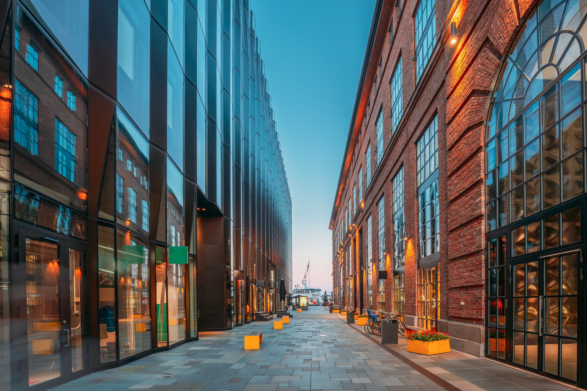 A narrow street between two tall buildings with lots of windows.