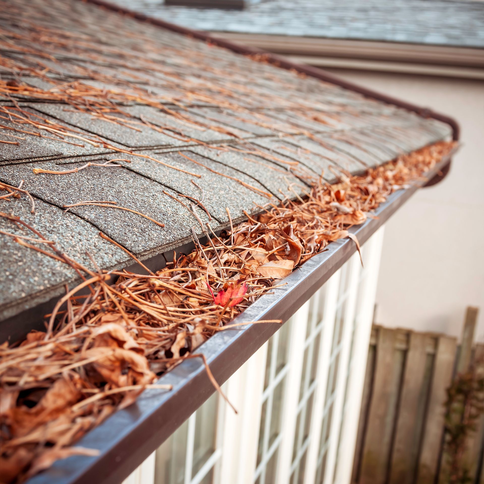 A brown gutter is on the side of a house