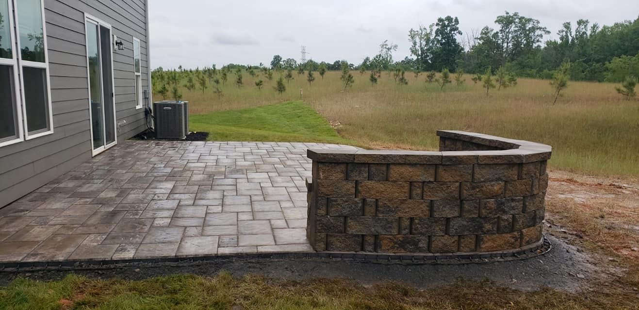 A paver concrete patio with border retaining wall in Rock Hill, SC by Carolina Mega Concrete LLC