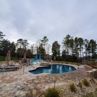 A travertine pool deck hardscape in Rock Hill, SC by Carolina Mega Concrete LLC
