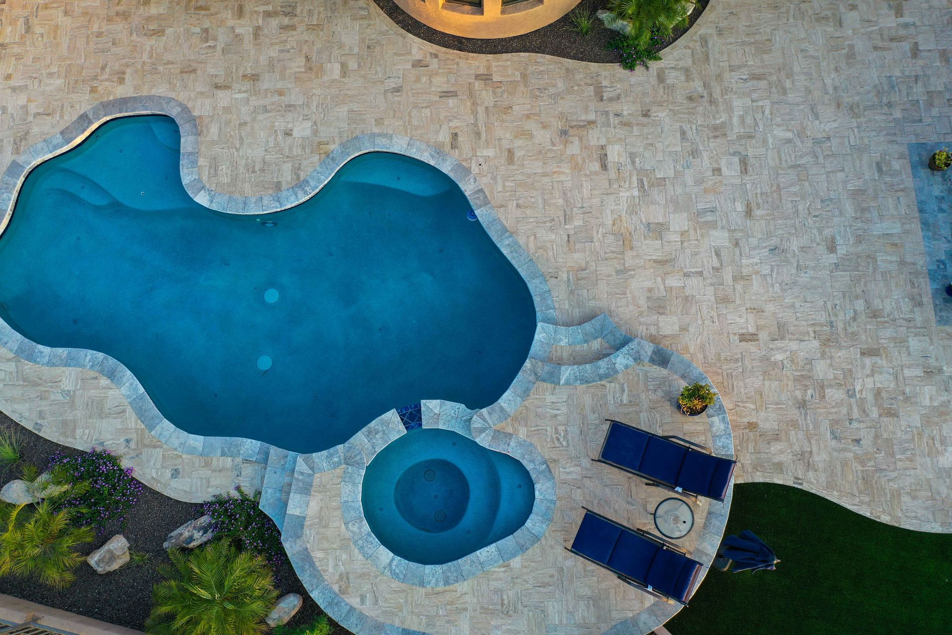 A travertine hardscape with a pool deck in Rock Hill, SC by Carolina Mega Concrete LLC