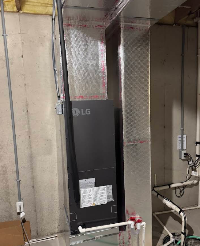 LG air handler unit in a basement, with ductwork and pipes.