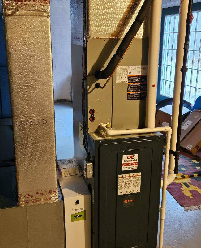 HVAC system in a basement setting. Includes a furnace, air handler, and humidifier with ductwork.