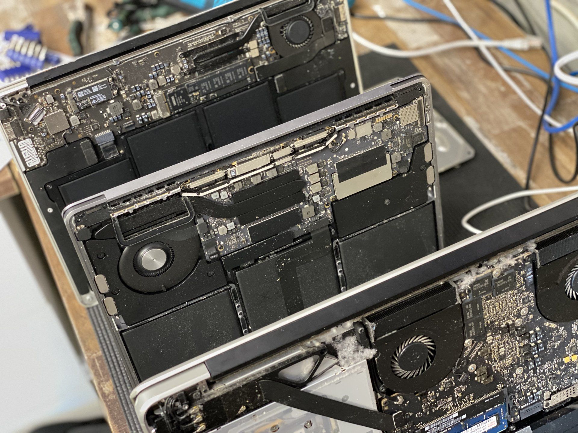 Three laptops are stacked on top of each other on a table.