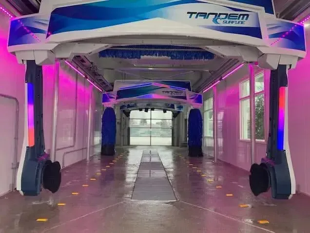 Empty futuristic corridor with magenta and blue lighting and a metallic archway overhead
