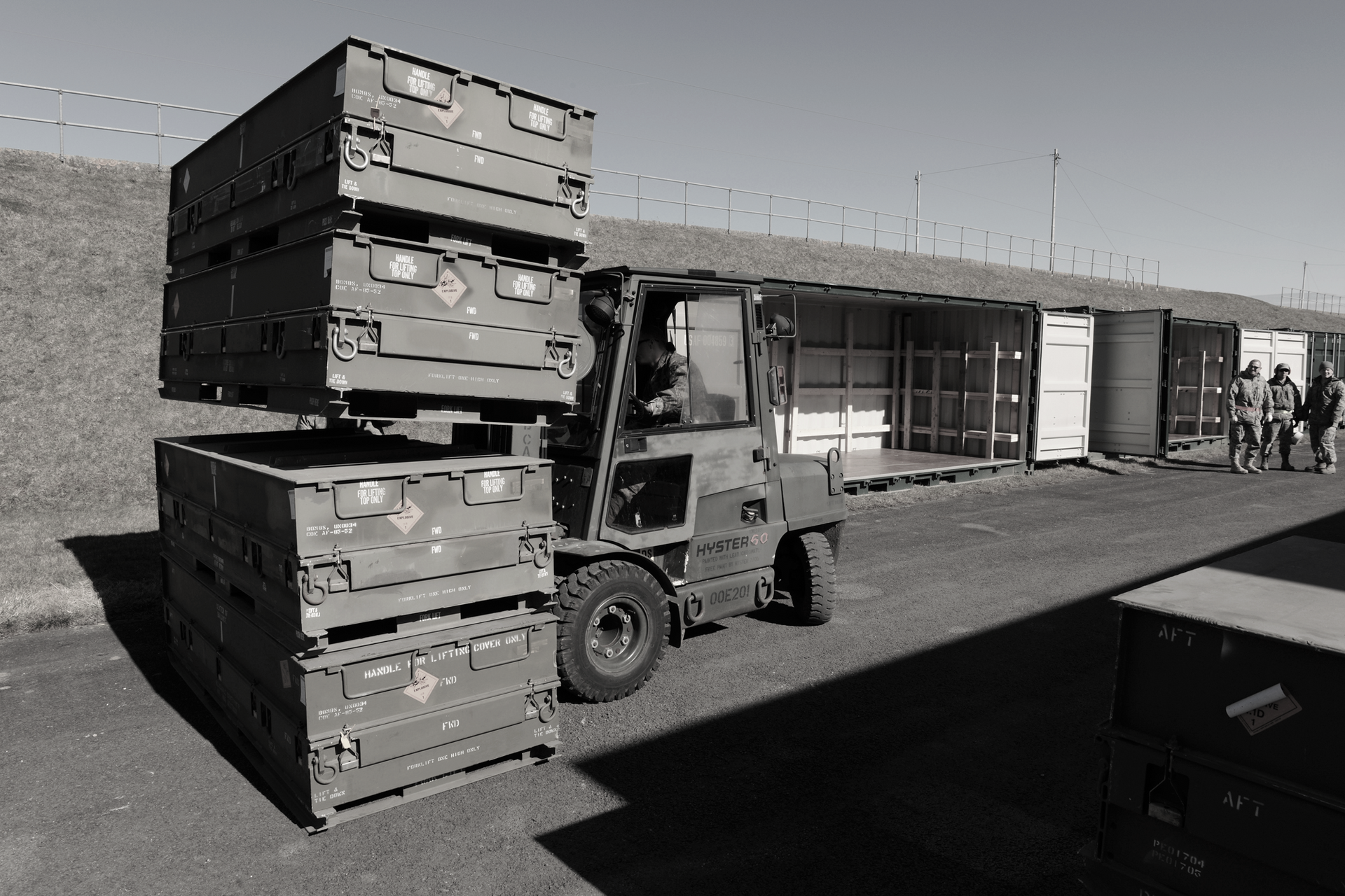 A black and white photo of a forklift carrying crates