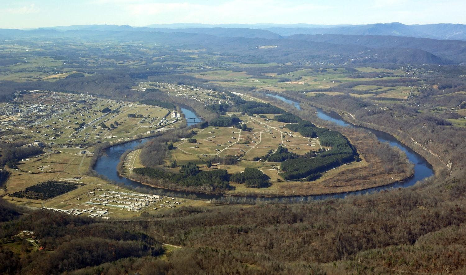 An aerial view of a river surrounded by trees and fields.