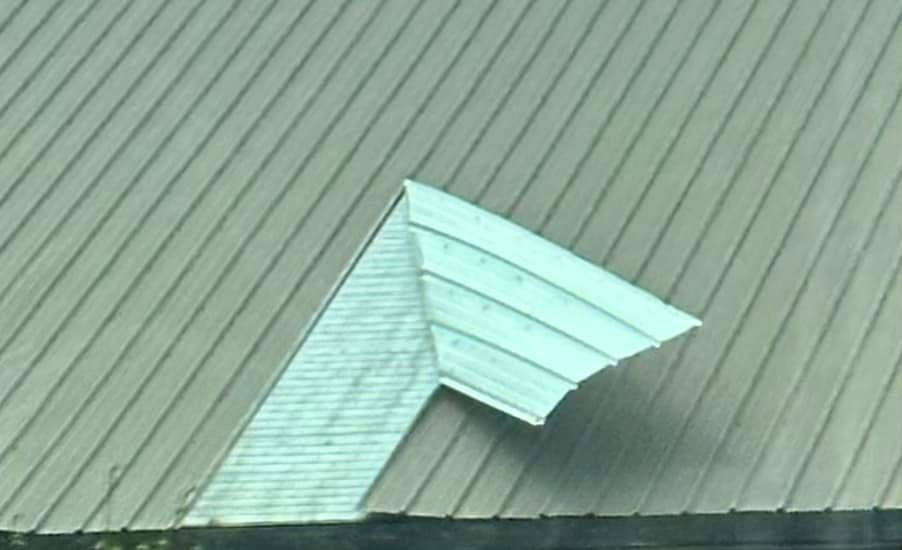 Overhead view of a metal roof with a smaller, lighter-colored roof extension.