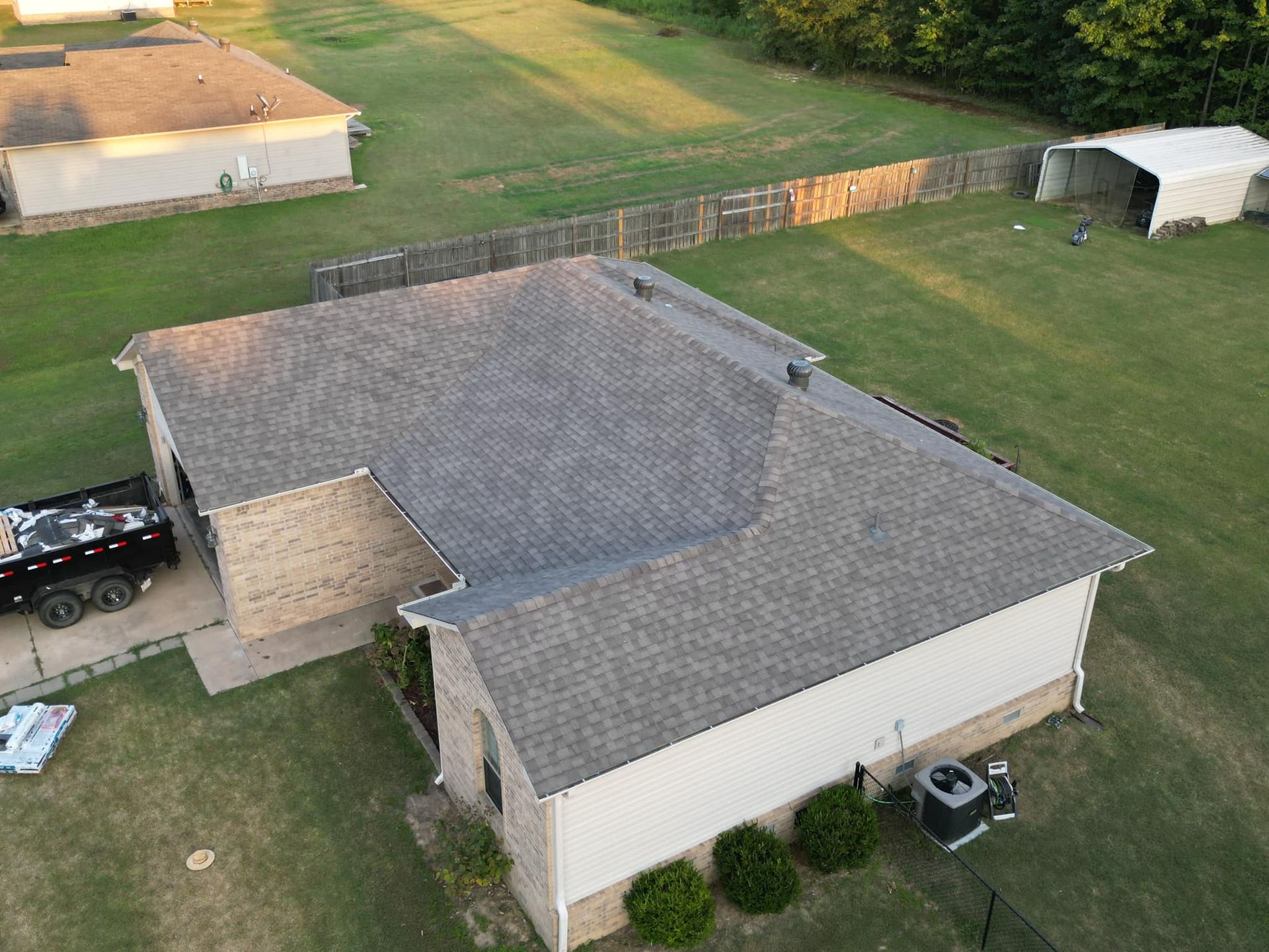 An aerial view of a house with a gray roof and a lawn.