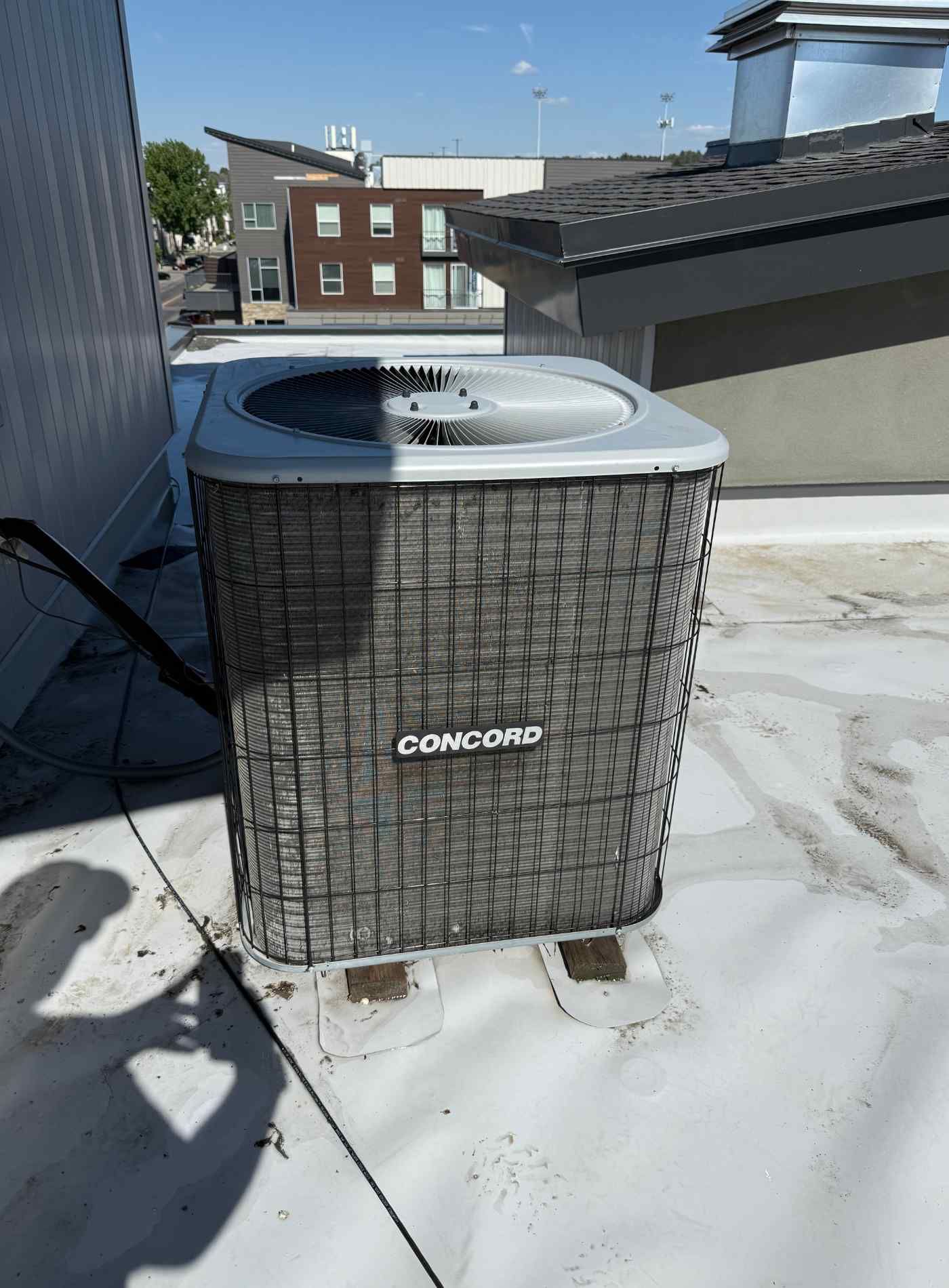 Concord air conditioner unit on a white roof, sunny day.