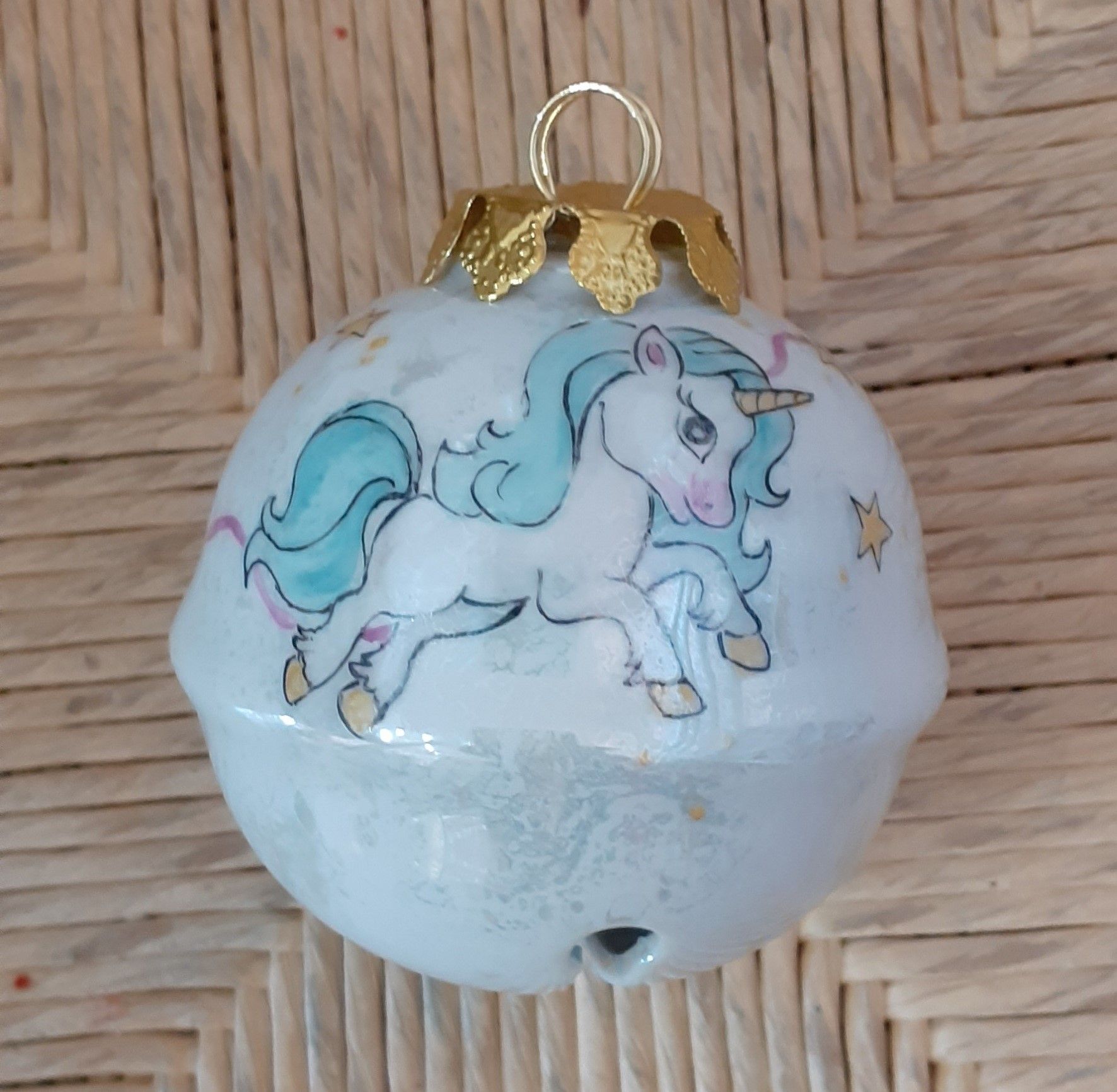 Campanella natalizia bianca con illustrazione di un unicorno e dettagli dorati.